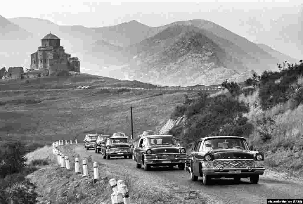 A convoy of Soviet Chaika cars glide along a road near Tbilisi, Georgia. The Chaika ('Seagull') was one of several Soviet cars that were copied nearly wholesale from their Western forerunners. 