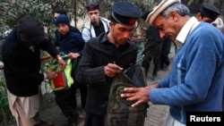 Students get their bags checked by school security staff at a school after it reopened in Peshawar in January.