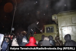 Участник антиправительственного протеста лезет на военный грузовик. Львов, 20 января 2014 года.
