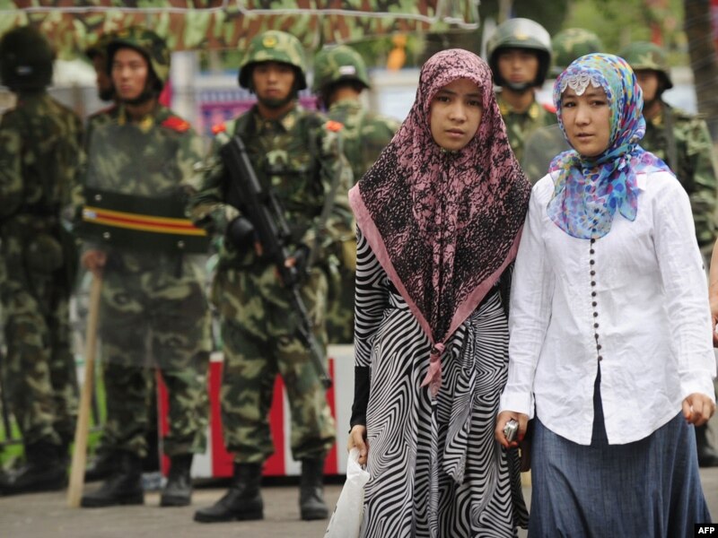 Две женщины-мусульманки на рынке в уйгурском районе города Урумчи, контролируемом военными после подавления выступлений уйгуров. 14 июля 2009 года.