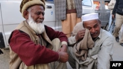Men react after learning that their relatives were among those killed in the bomb blast in Nowshera. 