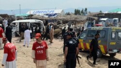 Pakistani security and medical personnel are pictured at the site of a car-bomb attack at the Jalozai refugee camp near Peshawar on March 21.