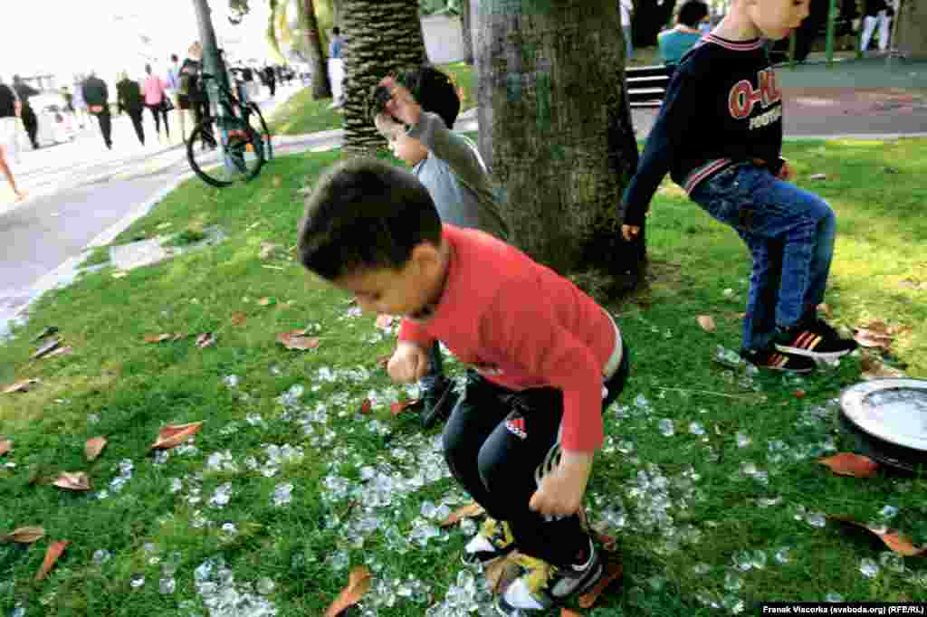 Children jump on the grass.