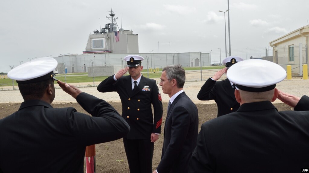 NATO Secretary General Jens Stoltenberg (center) reviews an honour guard during an inauguration ceremony for the U.S. antimissile site at a military base in Deveselu, Romania in May 2016.