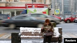 Пожилая женщина на скамейке в центре Москвы. 