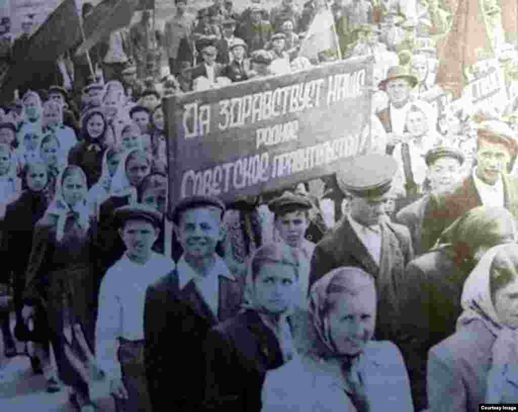 Sora mai mare Anastasia (a doua din dreapta, rândul de jos), la o demonstrație de sărbătoare în perioada sovietică. Pe pancartă scrie în limba rusă: „Să trăiască dragul nostru guvern sovietic”. Cișmichioi, circa începutul anilor 1960