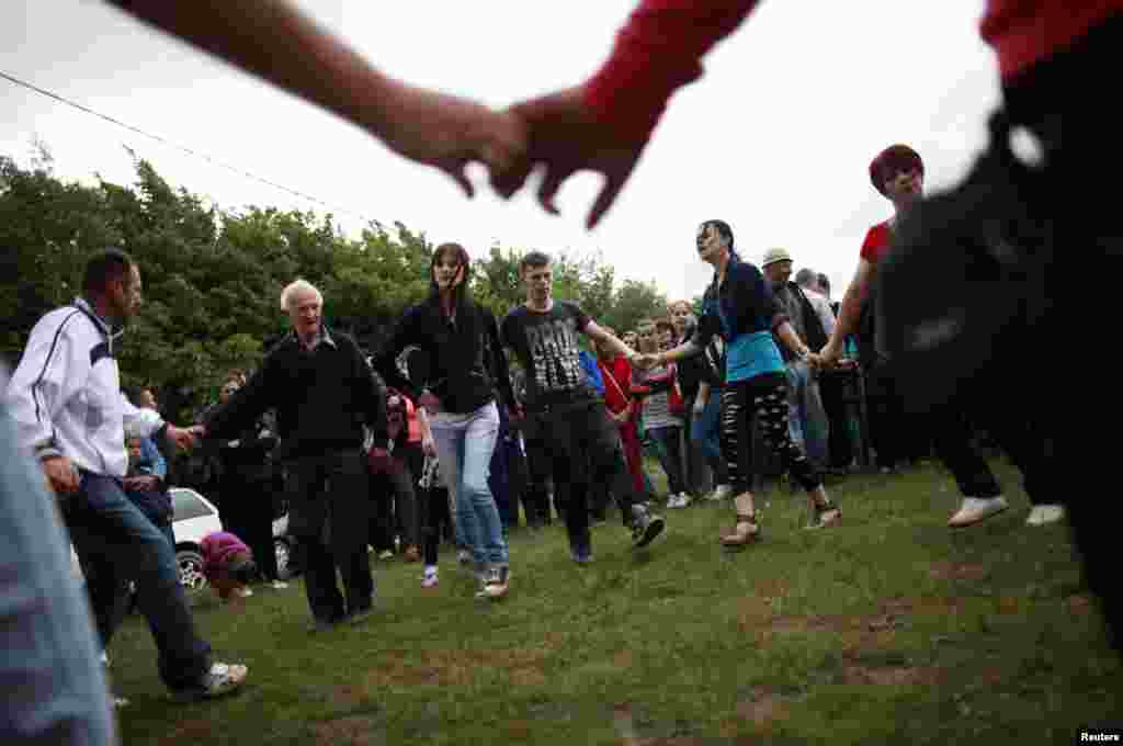 People dance on the sidelines of the bullfight.