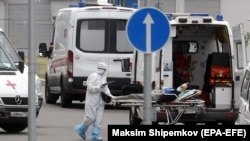 Egészségügyi dolgozók kórházba szállítanak egy koronavírusos beteget Moszkvában 2021. július 26-án