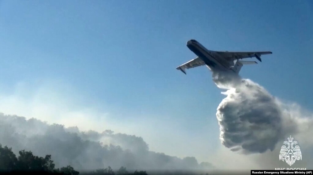 Another Beriev Be-200 aircraft drops its load of water.
