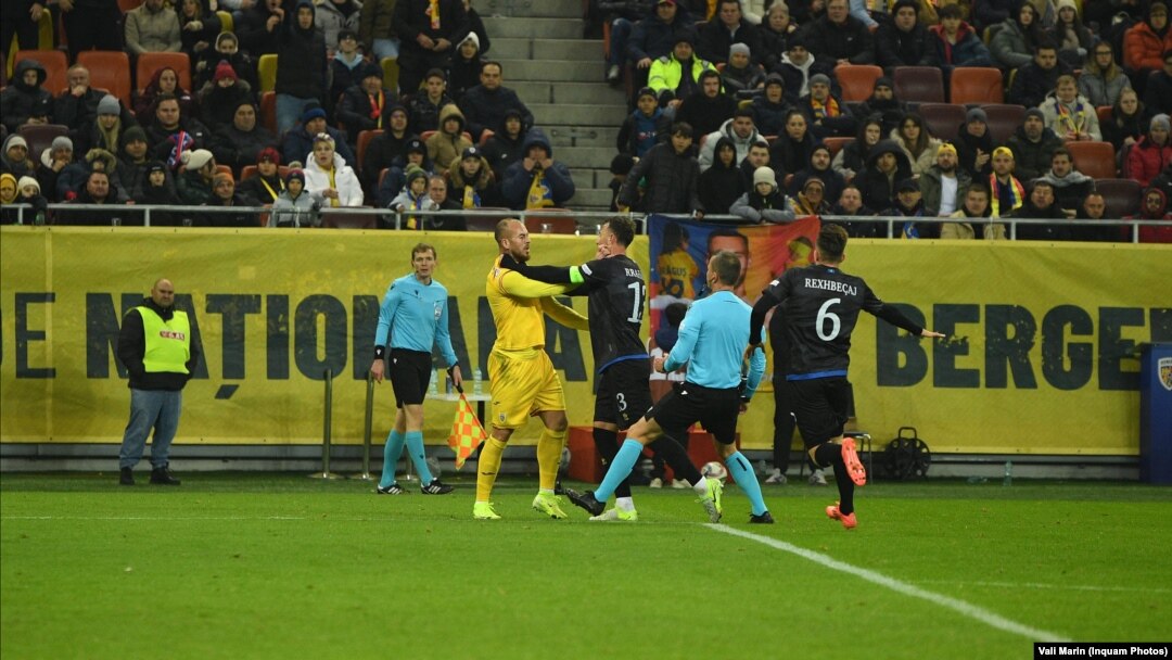 Căpitanul echipei din Kosovo, Amir Rrahmani (foto, în negru, cu banderolă verde pe braț) l-a prins de gât pe atacantul român Denis Alibec, după ce îl împinsese deja de două ori. Incidentul a angrenat și alți jucători și a precedat întreruperea definitivă a meciului.