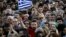 A protester sports the word "no" in Greek on his forehead as he waves a Greek flag during an antiausterity demonstration in Syntagma Square in Athens on July 3.