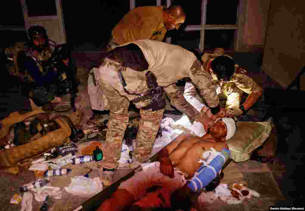 A special-forces soldier treats an Afghan National Army soldier who was injured in a firefight with the Taliban on June 12.&nbsp;