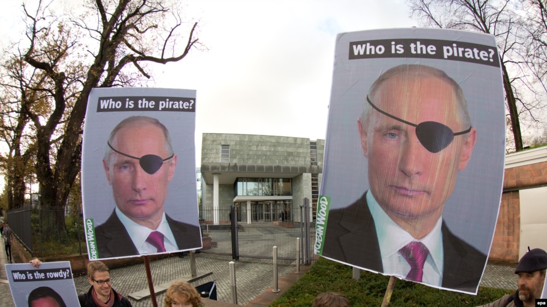Activists of the environmental organization Robin Wood hold placards depicting Russian President Vladimir Putin as they demonstrate in front of the International Tribunal for the Law of the Sea.