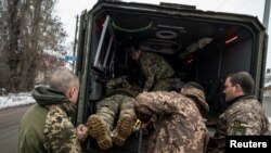 Ukrainian servicemen evacuate a wounded soldier amid fighting near the front line in the Donetsk region