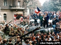 Czechoslovakia -- Czech youngsters holding a Czechoslovak flag stand atop an overturned truck as other Prague residents surround Soviet tanks in Prague on 21 August 1968