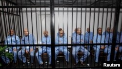 Бывшие чиновники режима Каддафи сидят за решеткой во время слушания вердикта в зале суда в Триполи. Ливия, 28 июля 2015 года.
