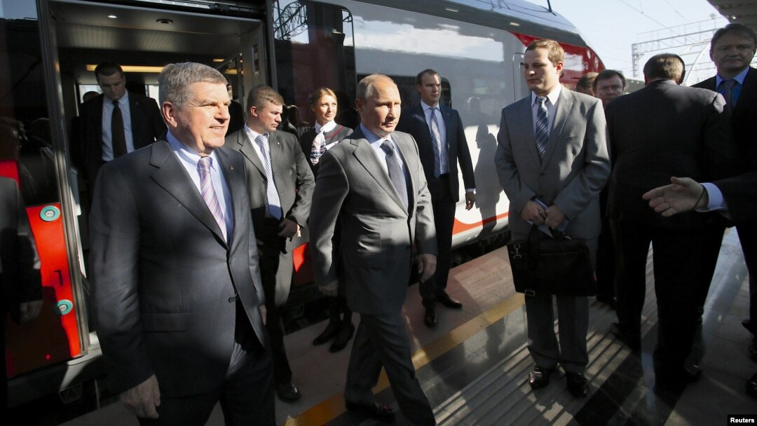 Russian President Vladimir Putin (center) and International Olympic Committee (IOC) President Thomas Bach (left front) exit a commuter train at a newly built railway station in Sochi on October 28.