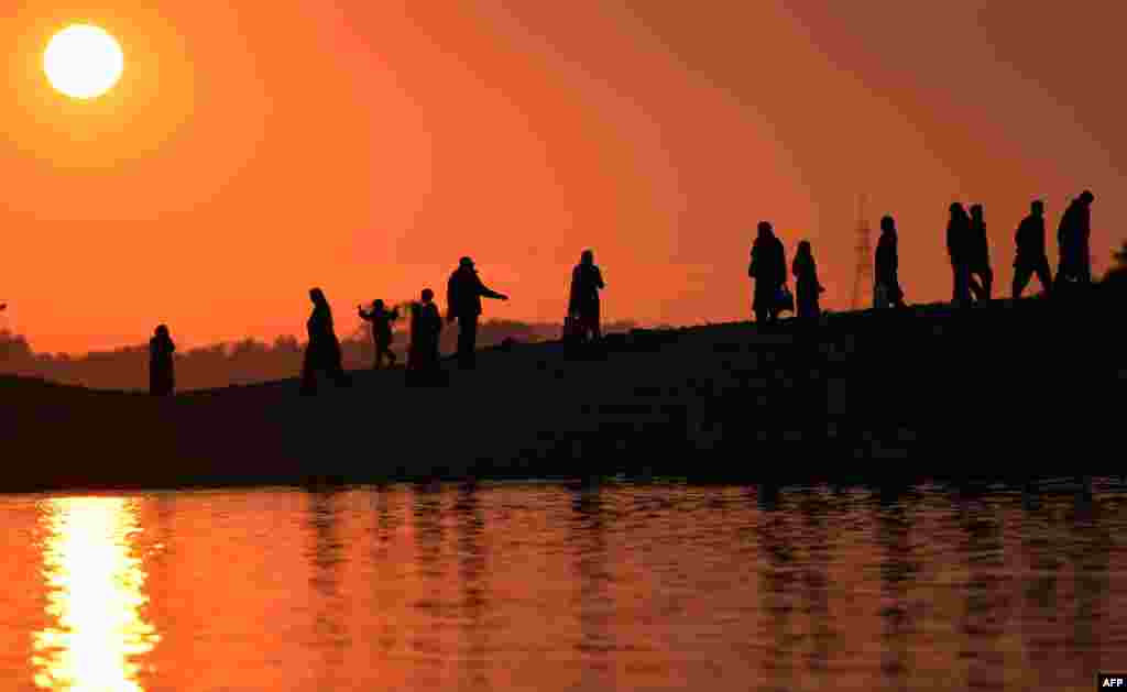 Pakistani pedestrians watch the last sunset of 2012 at a lakeview point in Islamabad. (AFP/Aamir Qureshi)