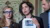 Nadezhda Tolokonnikova (center) -- with fellow Pussy Riot member, Maria Alyokhina (left), and husband Pyotr Verzilov (right) -- holds a list of names of individuals they believe should be sanctioned under the Magnitsky Act, in Washington on May 6. 