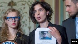 Надежда Толоконникова и Мария Алехина (слева) представляют свой список из 16 имен для введения против них санкций. Вашингтон, 6 мая 2014 года.