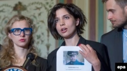 Nadezhda Tolokonnikova (center) -- with fellow Pussy Riot member, Maria Alyokhina (left), and husband Pyotr Verzilov (right) -- holds a list of names of individuals they believe should be sanctioned under the Magnitsky Act, in Washington on May 6. 