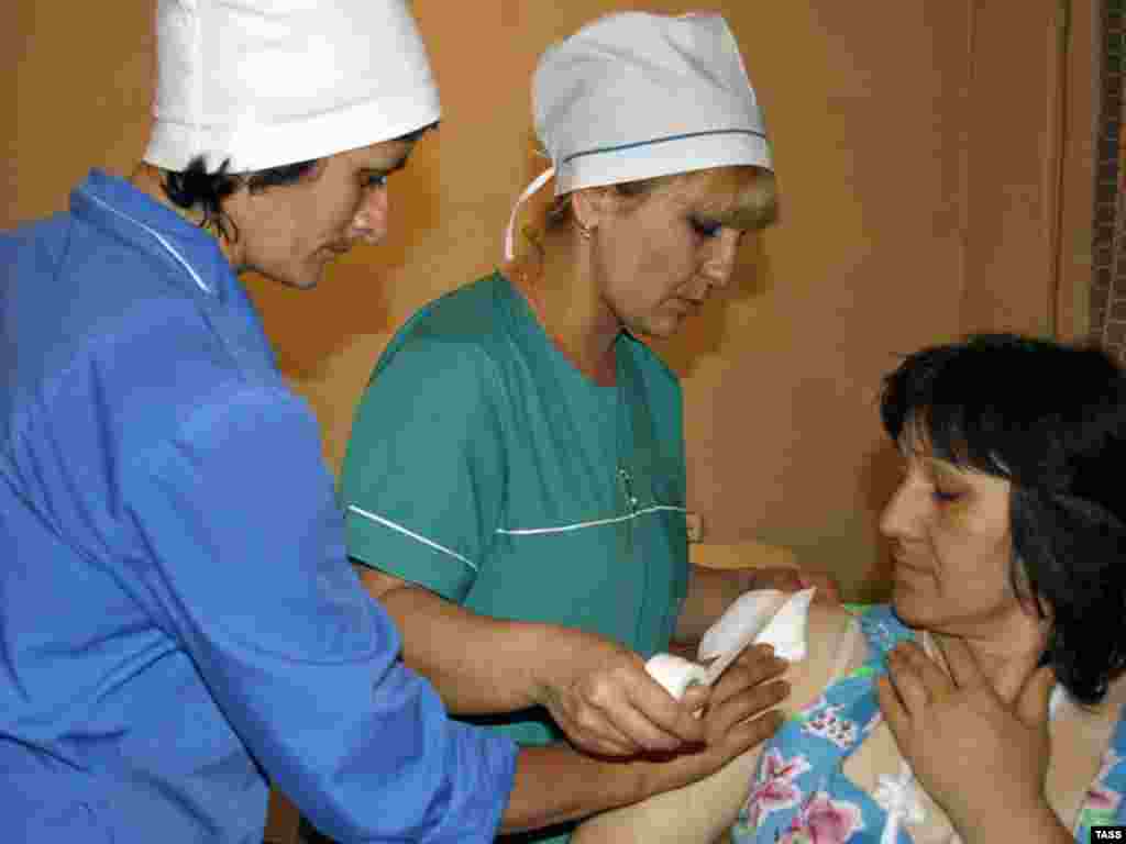 Georgia -- A woman with a bandaged and bleeding shoulder at a hospital in South Ossetia's Tskhinvali, 07Aug2008