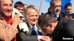 Crimean Tatars greet and escort Mustafa Dzhemilev (center) before attempting to pass a checkpoint connecting Ukraine's Kherson region and Crimea near the city of Armyansk on May 3.