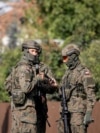 Ushtarë patrullojnë në rrugë pasi një dron ose objekt i ngjashëm goditi një ndërtesë banimi në komunën Wyryki të Polonisë.