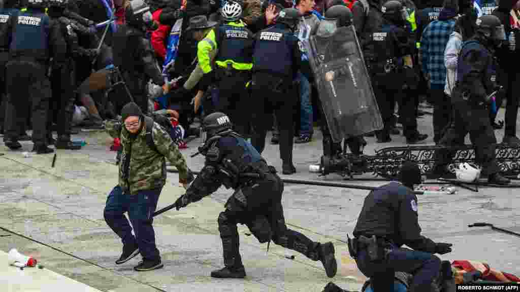 Столкновение толпы с полицией и силами безопасности во время штурма Капитолия.
