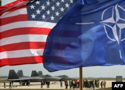The U.S. and NATO flags flutter as U.S. Air Force F-22 Raptor fighter jets land at the military air base in Siauliai, Lithuania, on April 27.