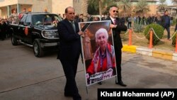 Mourners transport the flag-draped coffin of Iraqi archaeologist Lamia al-Gailani during her funeral procession in Baghdad on January 21.