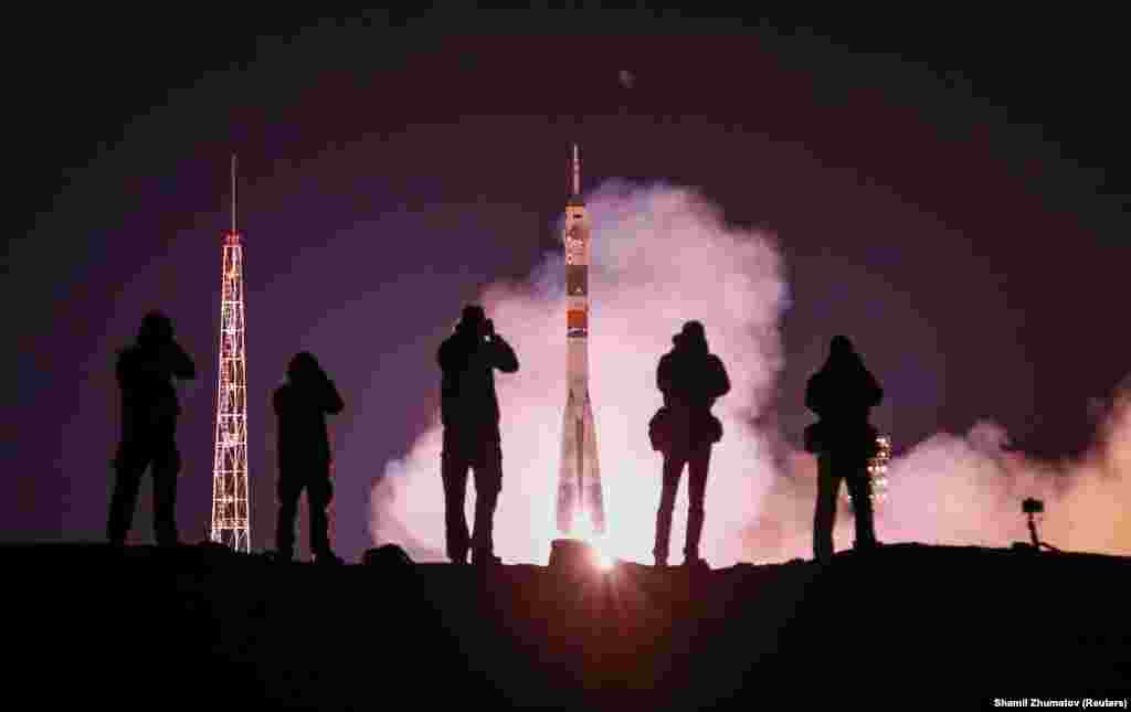 Photographers take pictures as a Soyuz MS-12 spacecraft carrying a three-person crew to the International Space Station blasts off on March 14. (Reuters/Shamil Zhumatov)