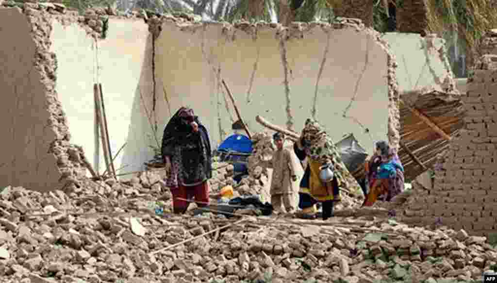 Residents walk on the debris of a house which collapsed during the earthquake in Awaran .