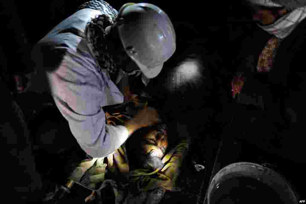 Miners wash the face of their colleague who died in a mine collapse.