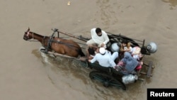 Një familje pakistaneze duke u larguar nga territori i përfshirë nga vërshimet në Pakistan