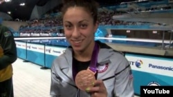 Elizabeth Stone shows one of her bronze medals during the victory ceremony in London in August.