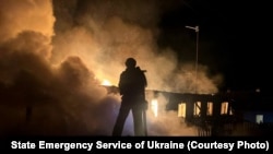 Орус армиясынын дрон соккусунан улам тутанган тилсиз жоо менен күрөшүп жаткан өрт өчүрүүчү. 20-апрель, 2026-жыл. Харьков. 