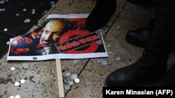 ARMENIA -- A placard with an image of Prime Minister Nikol Pashinian is seen lying on the ground among coins during a rally to demand his resignation, December 10, 2020.
