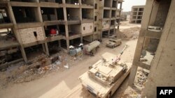 Фалужжа аймагында "Ислам мамлекетине" каршы согушуп Ирактын согуштук танкасы жана башка техникалары. Душмандарга көрүнбөсүн деп атайын түсүн бойоп коюшкан. 10-сентябрь, 2015-жыл