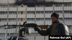  An Afghan police officer stands guard in front of the Intercontinental Hotel in Kabul.