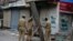 Indian police officers erect a tin and barbed wire barricade in Srinagar, the summer capital of Kashmir on July 11.