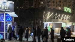 Locuitorii stau la coadă pentru a umple sticle cu apă potabilă proaspătă în timpul întreruperilor de curent din Kiev. 24 ianuarie 2026.