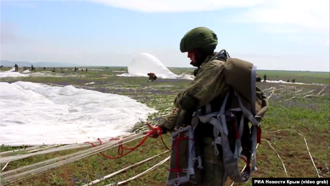Российский десантник складывает парашют на полигоне «Опук» в Крыму, май 2021 года