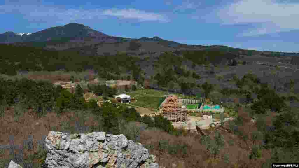 С вершины скалы видно, что на большом участке неподалеку завершается строительство православного храма, оборудовано поле для мини-футбола, детская площадка и несколько современных бунгало