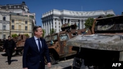Sekretari i Jashtëm i Britanisë së Madhe, David Cameron, ec pranë automjeteve të shkatërruara ushtarake të Rusisë, të shfaqura në sheshin Saint Michael, në Kiev, Ukrainë, 2 maj 2024.

