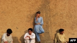 Villagers , their clothes stained with the blood of victims, rest after helping with rescue efforts following a suicide bombing near a mosque in the semi-tribal village of Darra, Pakistan