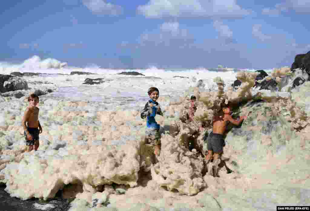 Children play in sea foam generated by cyclone Oma at Snapper Rocks on the Gold Coast, Queensland, Australia. (epa-EFE/Dan Peled)