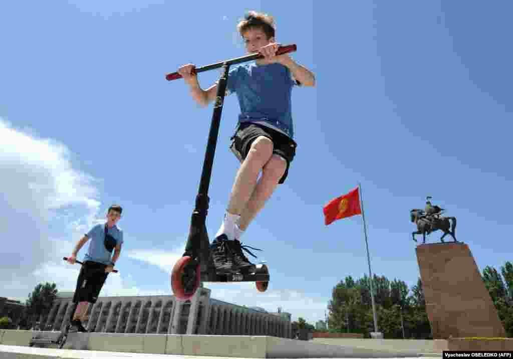 Kyrgyz boys ride scooters on International Children&#39;s Day in central Bishkek on June 1. (AFP/Vyacheslav Oseledko)