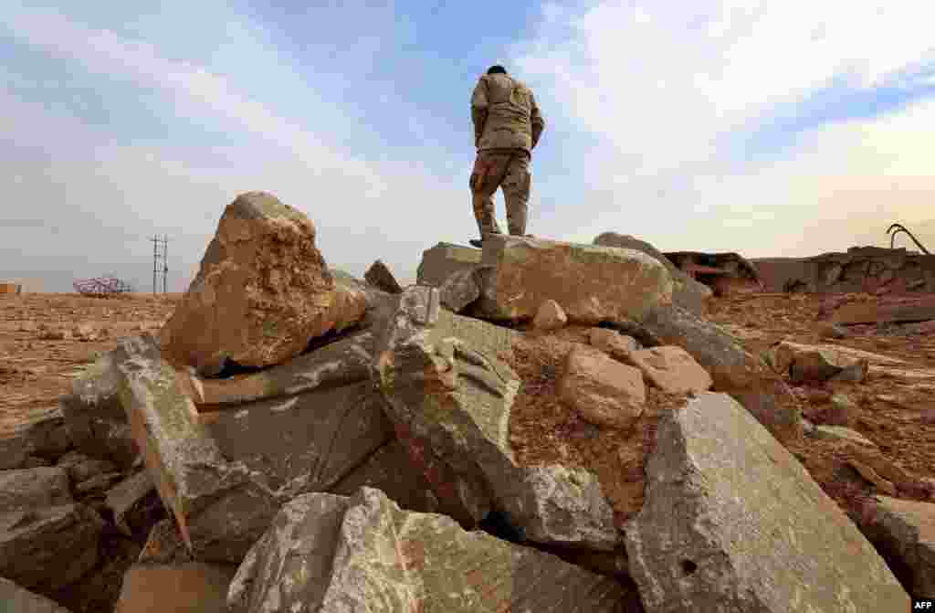 An Iraqi soldier stands on the ruins of an archaeological site