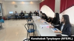 Алматыдағы №322 референдум учаскесіндегі комиссия мүшелері (оң жақ қанатта) және олардың арғы жағында бақылаушылар / байқаушылар отыр, Алматы, 15 наурыз, 2026 жыл.